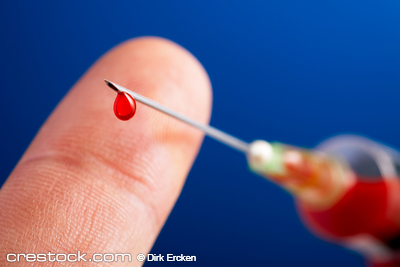 syringe needle with droplet of blood in front ...
